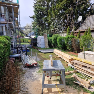 Baustelle - Holzbalken und Schneidemaschine im Garten