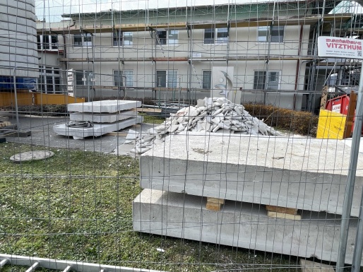 Wohnhaus mit Baustellenzaun und Baustellenschutt