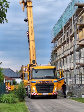 Haus mit Gerüst und Baufahrzeug