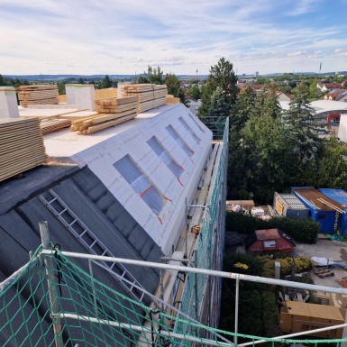 Baustelle Schrägdach Außenansicht von oben mit Himmel und Bäumen im Hintergrund