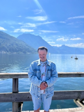 Mann steht am Steg vor dem See