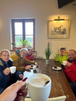 Eine Gruppe Menschen um einen Tisch mit Kaffeetassen.