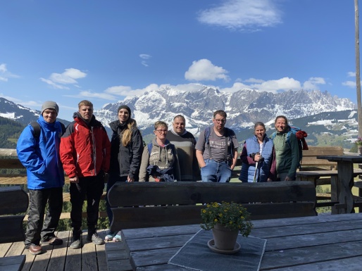 Gruppenfoto von Männern und Frauen mit schneebedeckten Bergen im Hintergrund