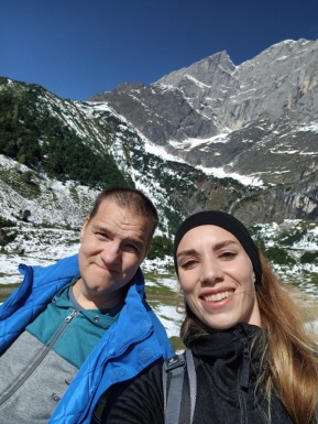 Mann und Frau stehen vor einem schneebedecktem Berg
