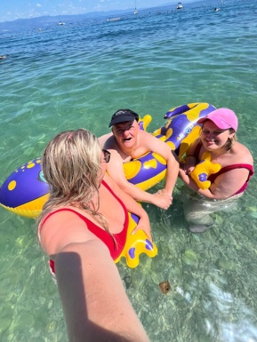 Drei Menschen im Meer mit Schwimmtier