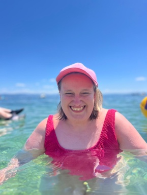 Frau lächelt und steht im Meer