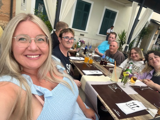 Menschengruppe lächelnd sitzt gemeinsam beim Tisch