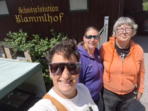 Selfie von drei Frauen die lächeln und vor einem Hotel stehen