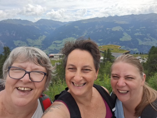 Selfie von drei lächelnden Frauen mit Bergen im Hintergrund