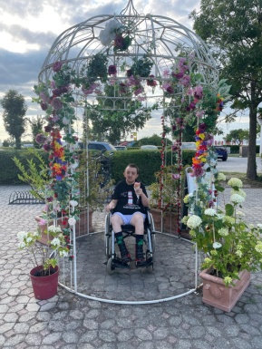 Mann im Rollstuhl mit Eis unter Blumen Pavillon
