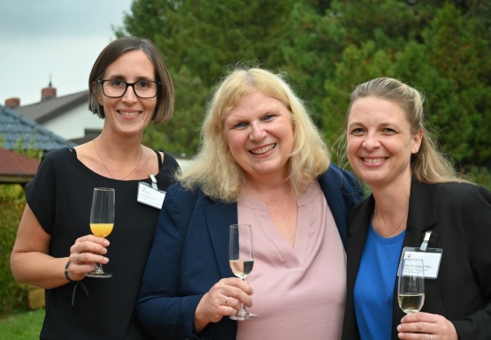 Drei lächelnde Frauen mit Sektgläsern