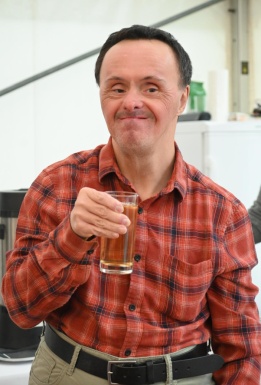 Portraitfoto von einem Mann der ein Glas hält