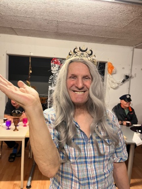 Mann mit Frauenperücke winkt