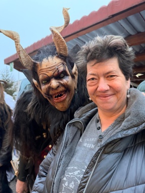 Frau mit Person die als Krampus maskiert ist