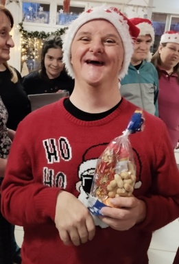 Bewohner mit Weihnachtsm&uuml;tze und Nikolaussackerl l&auml;chelt