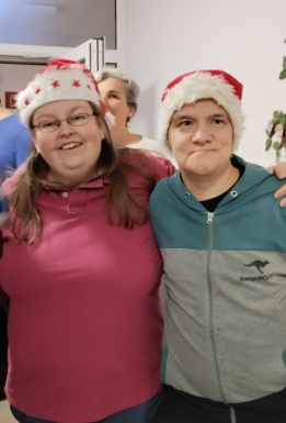 Mann und Frau umarmen sich freundschaftlich und tragen Weihnachtsm&uuml;tzen