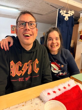 Mann und Frau sitzen nebeneinander und l&auml;cheln