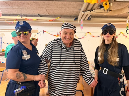 Zwei Frauen als Polizistinnen verkleidet mit Mann der als Str&auml;fling verkleidet ist