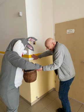 Osterhase &uuml;bergibt einem Mann ein Ei