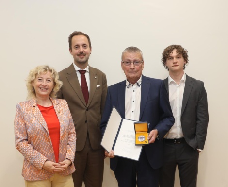 Gruppenfoto mit Obmann der das Abzeichen und die Urkunde in H&auml;nden h&auml;lt