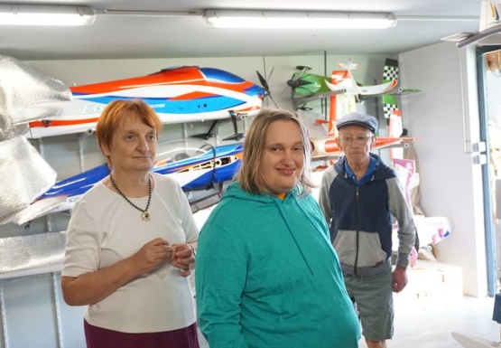 Zwei Frauen und ein Mann vor Modellflugzeugen