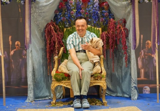 Mann sitzend vor Blumen