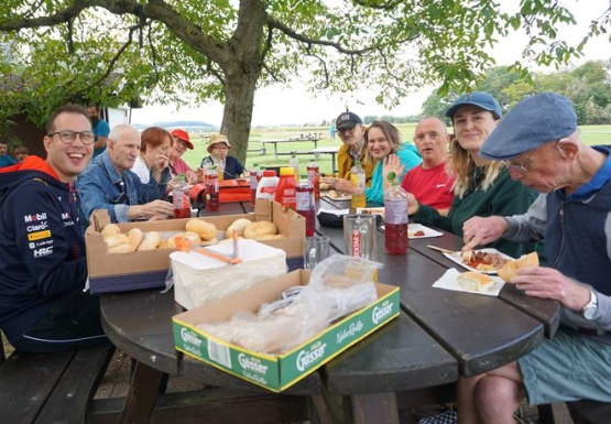 Gruppenfoto beim Esstisch im Freien