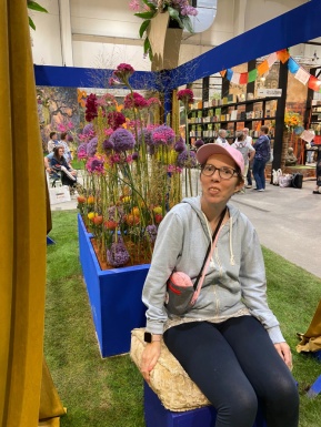 Frau sitzend vor Blumen