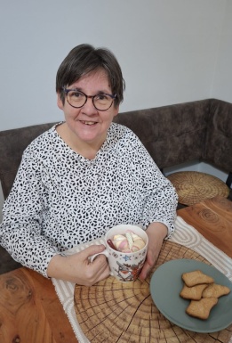 Frau mit Kakao und Keksen beim Tisch