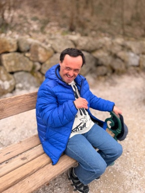 Ein Mann sitzt auf einer Bank und l&auml;chelt