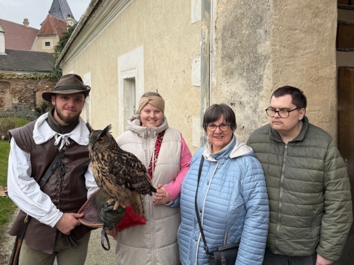 Gruppenbild mit einem Mann der eine Eule auf seinem Handschuh sitzen hat
