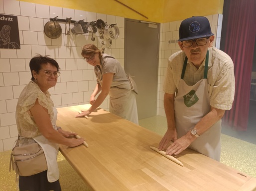 Zwei Frauen und ein Mann beim Formen eines Geb&auml;ckst&uuml;ckes