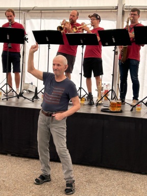 Ein Mann tanzt vor der B&uuml;hne vor den Musikanten