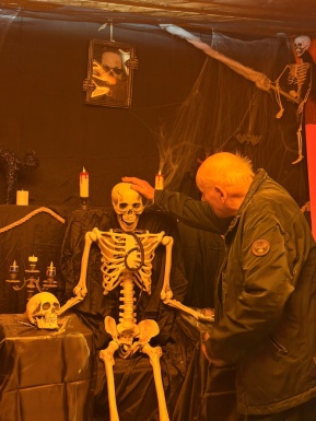 Ein Mann legt seine Hand auf ein Halloween Skelett