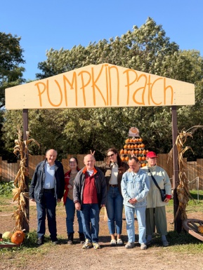 Gruppenfoto vor einem Schild mit der Aufschrift Pumpkin Patch