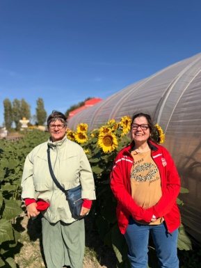 Zwei Frauen stehen vor einem Sonnenblumenfeld