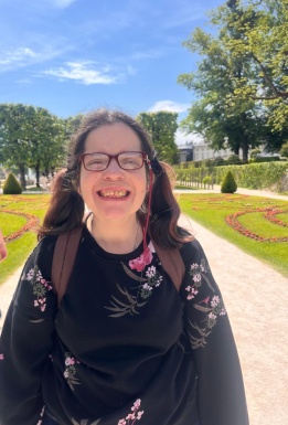 Frau lachend mit Brille in einem schönen Garten