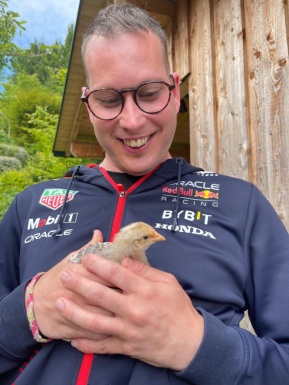 Mann freudestrahlend mit Küken in der Hand