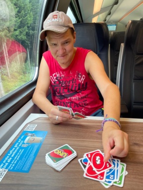Mann im Zug spielt Karten