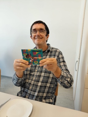 Mann mit Geburtstagsgeschenk in der Hand lächelt