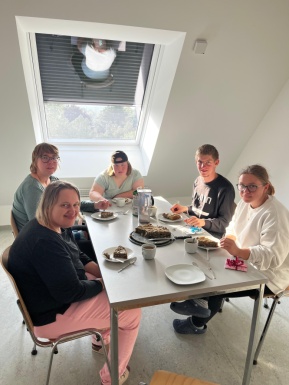 Gruppenfoto bei gedecktem Tisch mit Kaffeejause