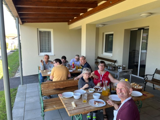 Menschen sitzen auf der Terrasse zusammen und essen gemeinsam