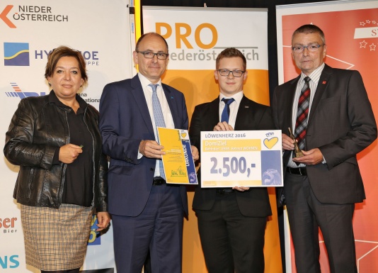 Gruppenbild mit einer Frau und drei Männern mit einer Schecktafel über 2.500 Euro und der Löwenherz Auszeichnung in der Hand