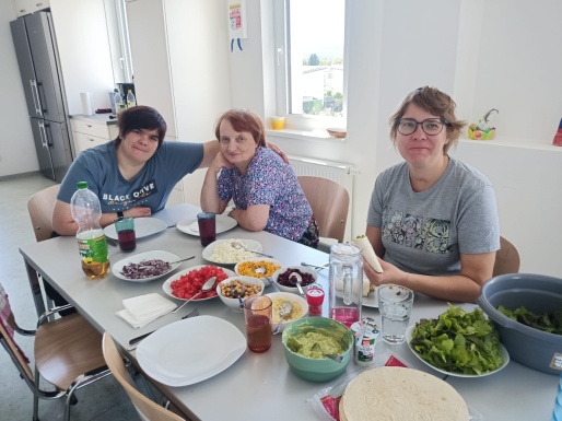 Drei Frauen sitzen am mit Essen gedeckten Tisch