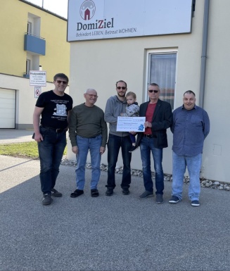 Menschen mit Kleinkind bei Spendenübergabe