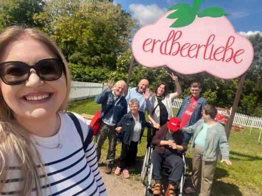 Gruppe von Menschen, die in die Kamera lächeln und winken