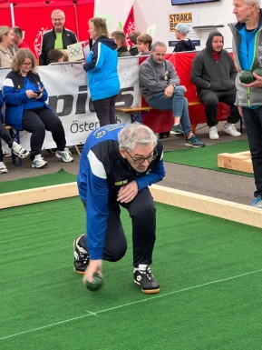 Mann der eine Bocciakugel rollt