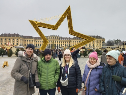 Gruppenfoto vom Weihnachtsmarkt in Schönbrunn mit Sternskulptur im Hintergrund