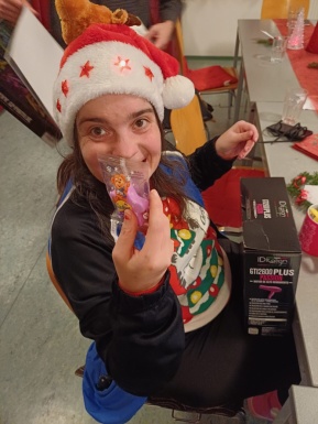 Frau mit Weihnachtsm&uuml;tze zeigt ihr Geschenk