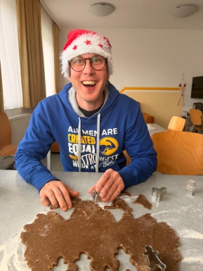 Mann mit Weihnachtsmütze beim Kekse Ausstechen